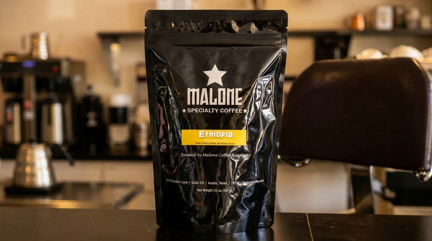 A black bag of Malone Specialty Coffee, Ethiopia blend, sits on a counter in a coffee shop.