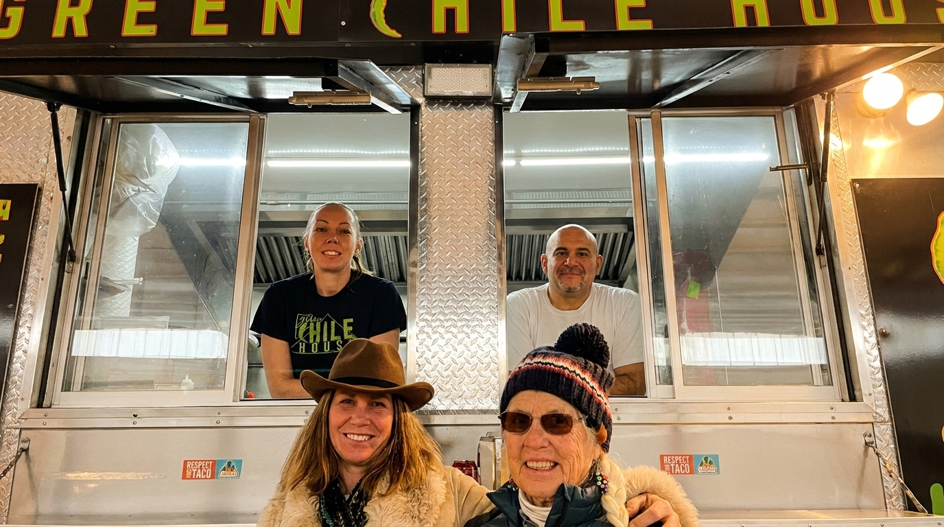 Four smiling people, two customers and two Green Chile House employees, pose in front of a food truck.