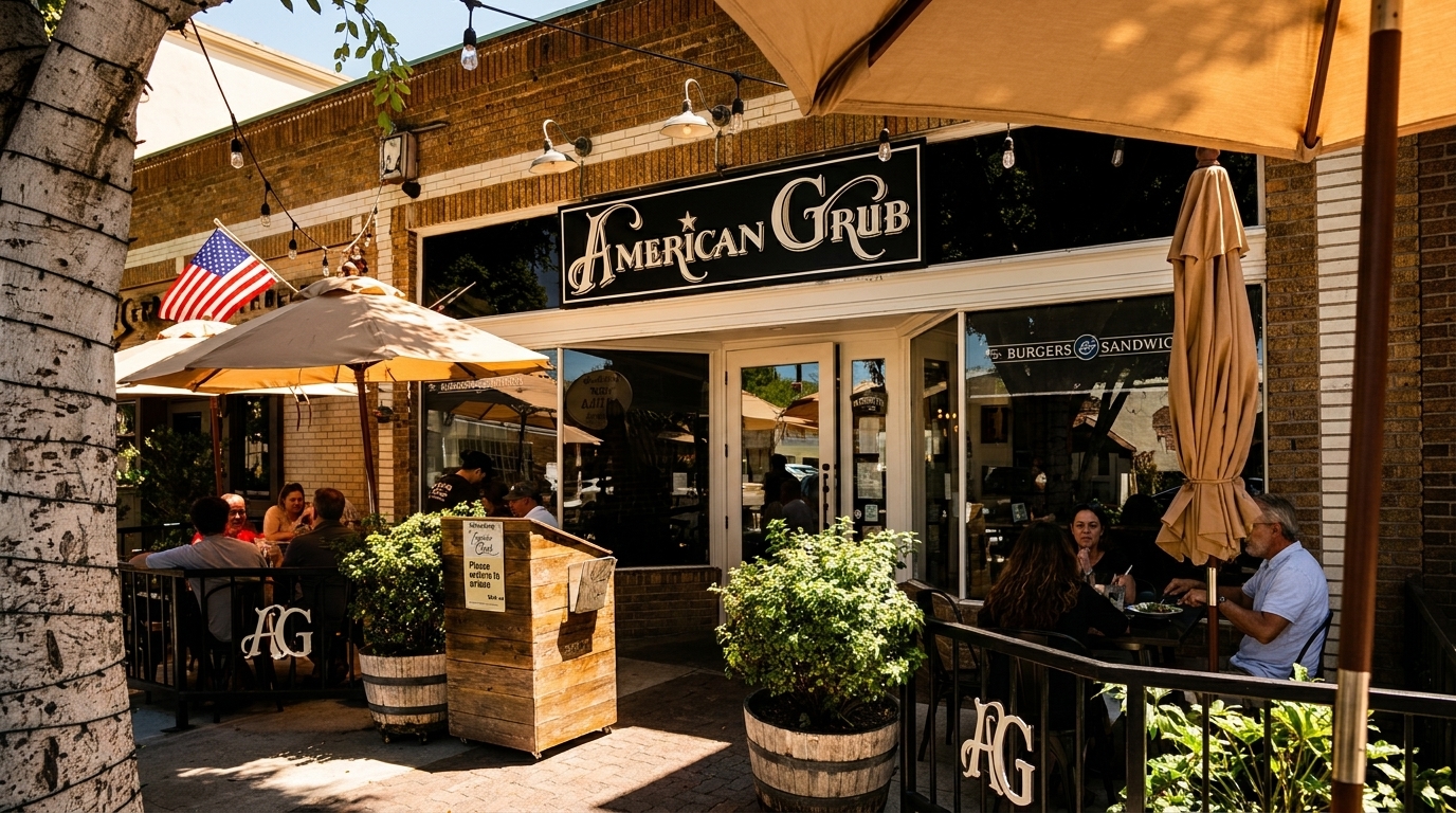 Diners enjoy outdoor patio seating at American Grub restaurant, with umbrellas and an American flag.