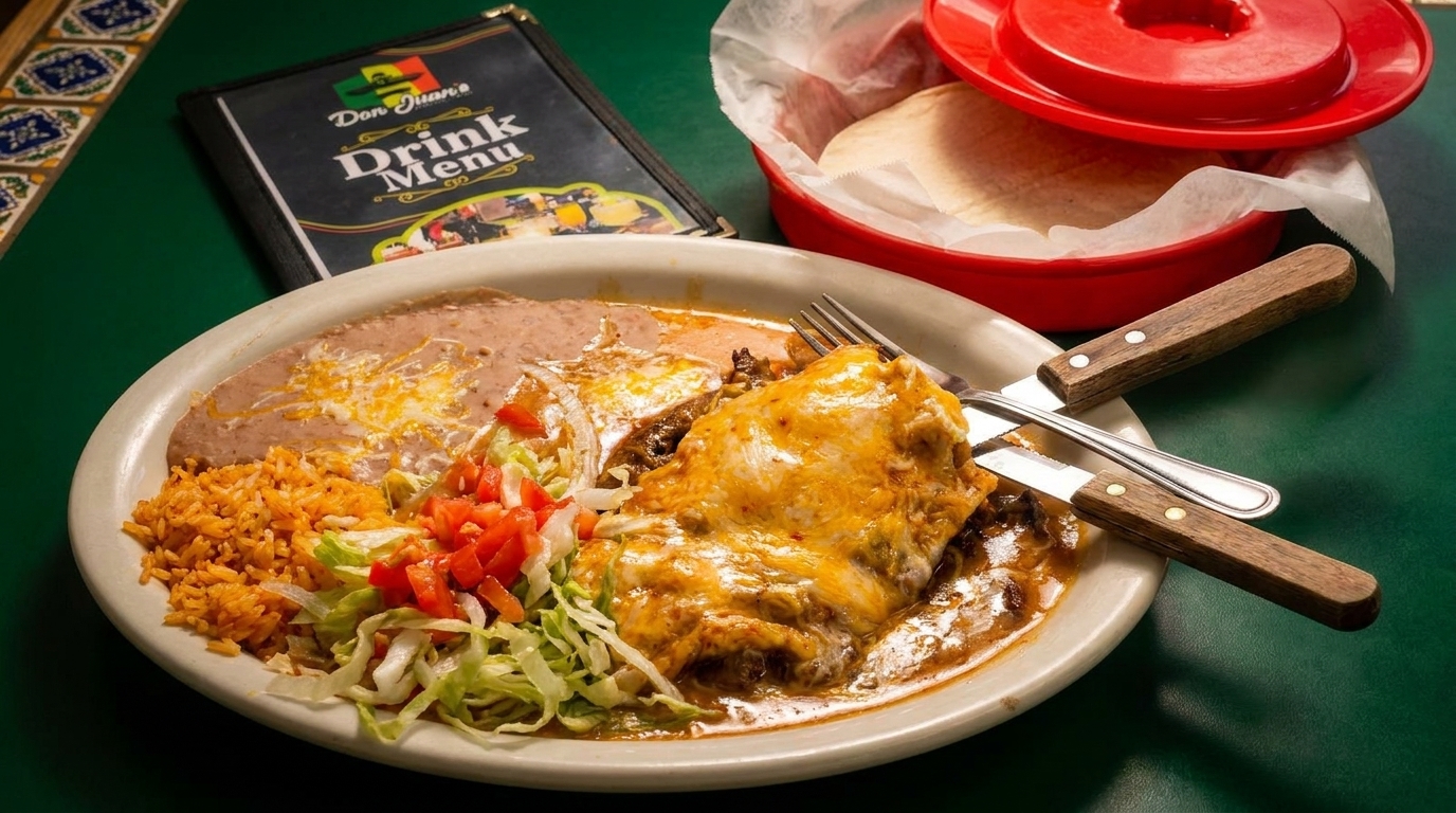 Don Juan's Mexican food plate with enchiladas, rice, beans, salad, and tortillas on a green table.