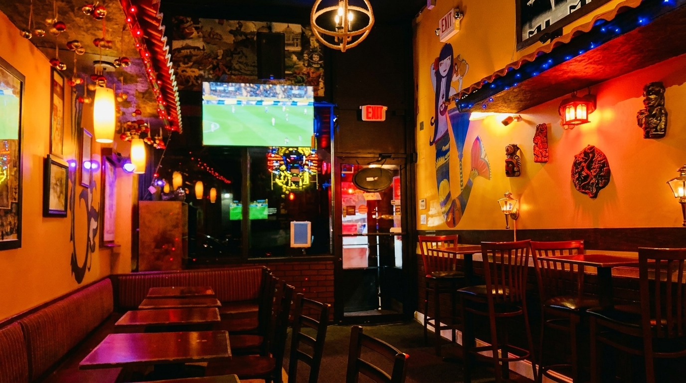 A vibrant, dimly lit restaurant interior with booths, high-top tables, decorative lighting, and wall art.