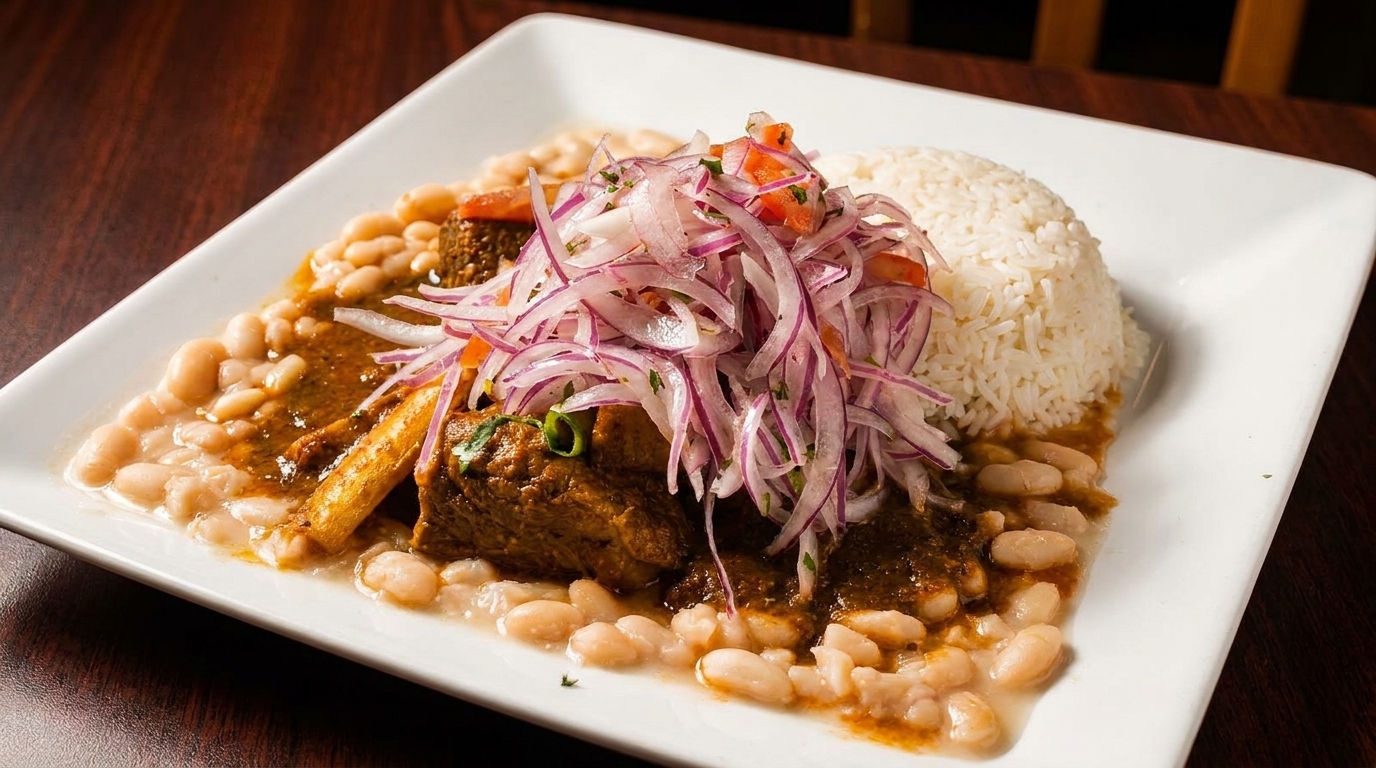 Peruvian seco de res with white beans, rice, and a red onion salsa criolla on a white plate.