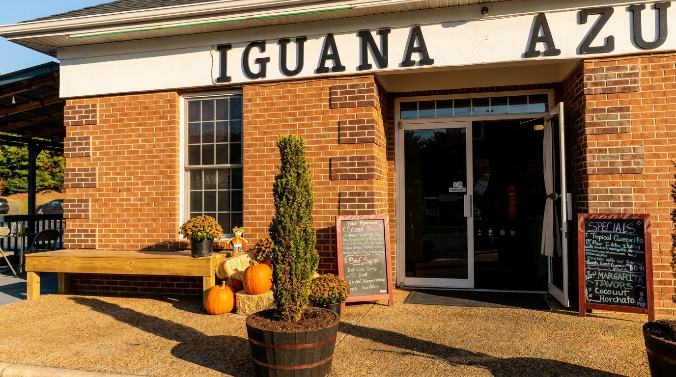 Exterior of Iguana Azul restaurant with brick facade, open door, and fall decorations.