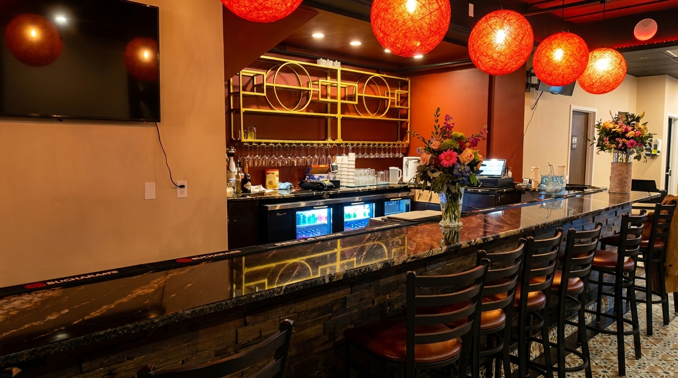 A stylish restaurant bar with red orb lights, a dark marble counter, and bar stools.