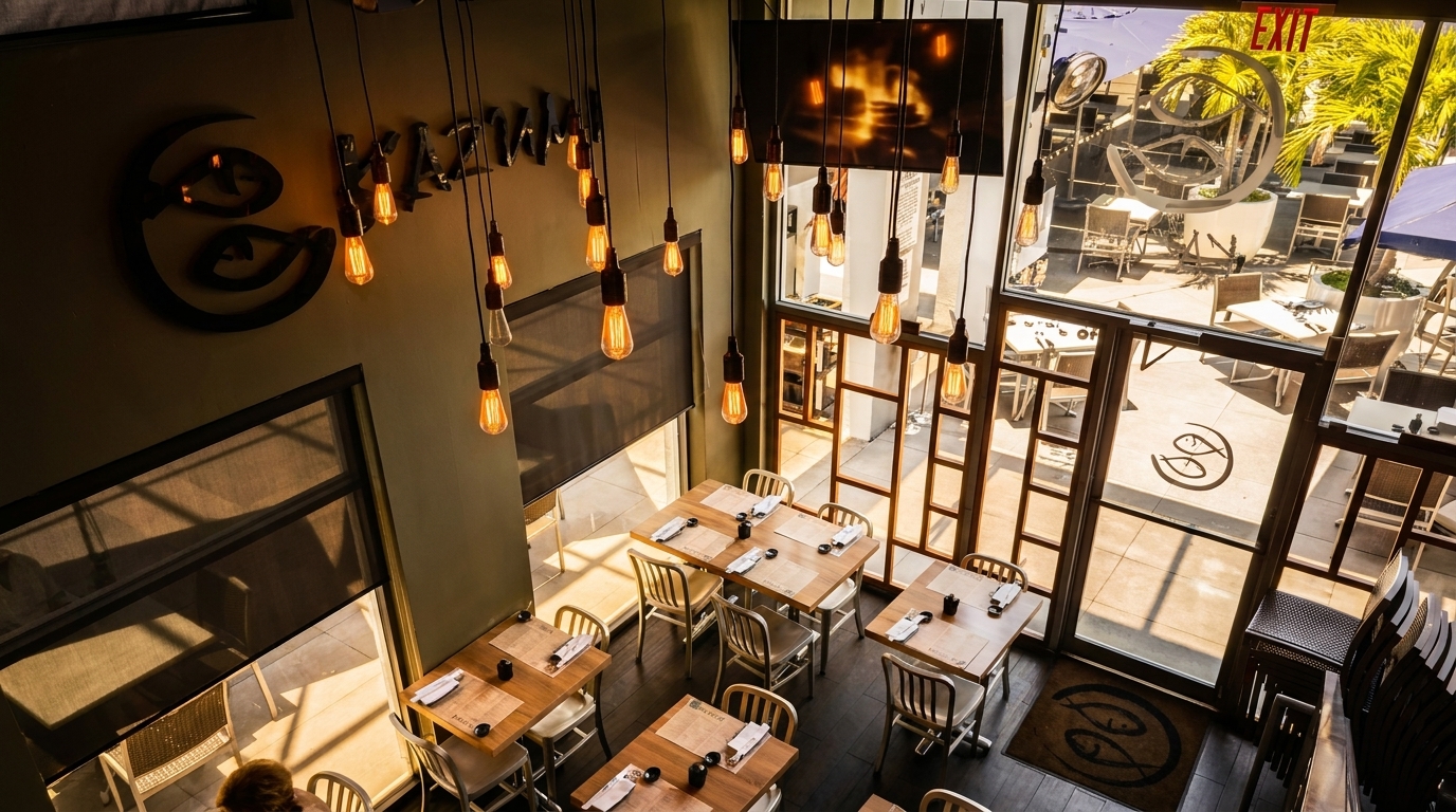 Overhead view of a restaurant interior with wooden tables, industrial lighting, and an outdoor patio.