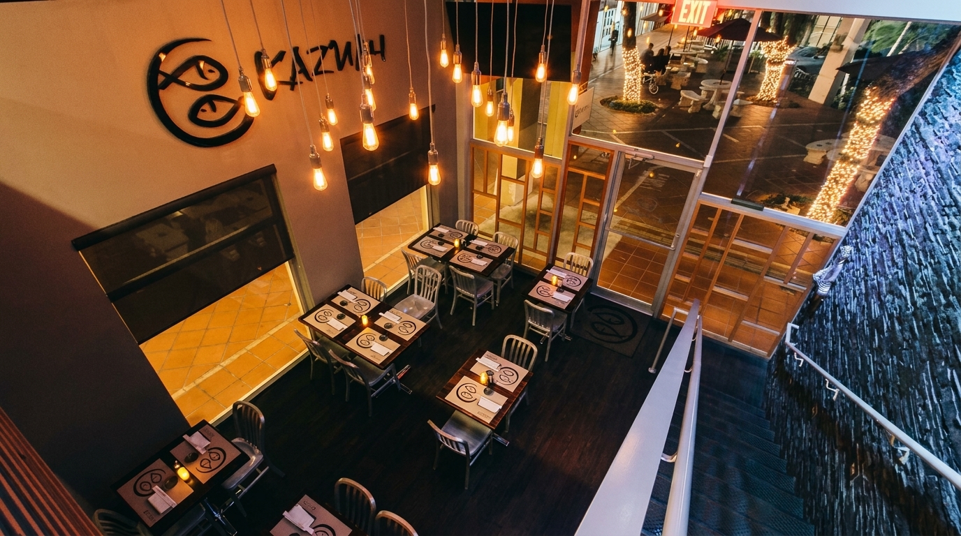 Overhead view of Kazbah restaurant interior with tables, hanging Edison bulbs, and an outdoor patio visible.