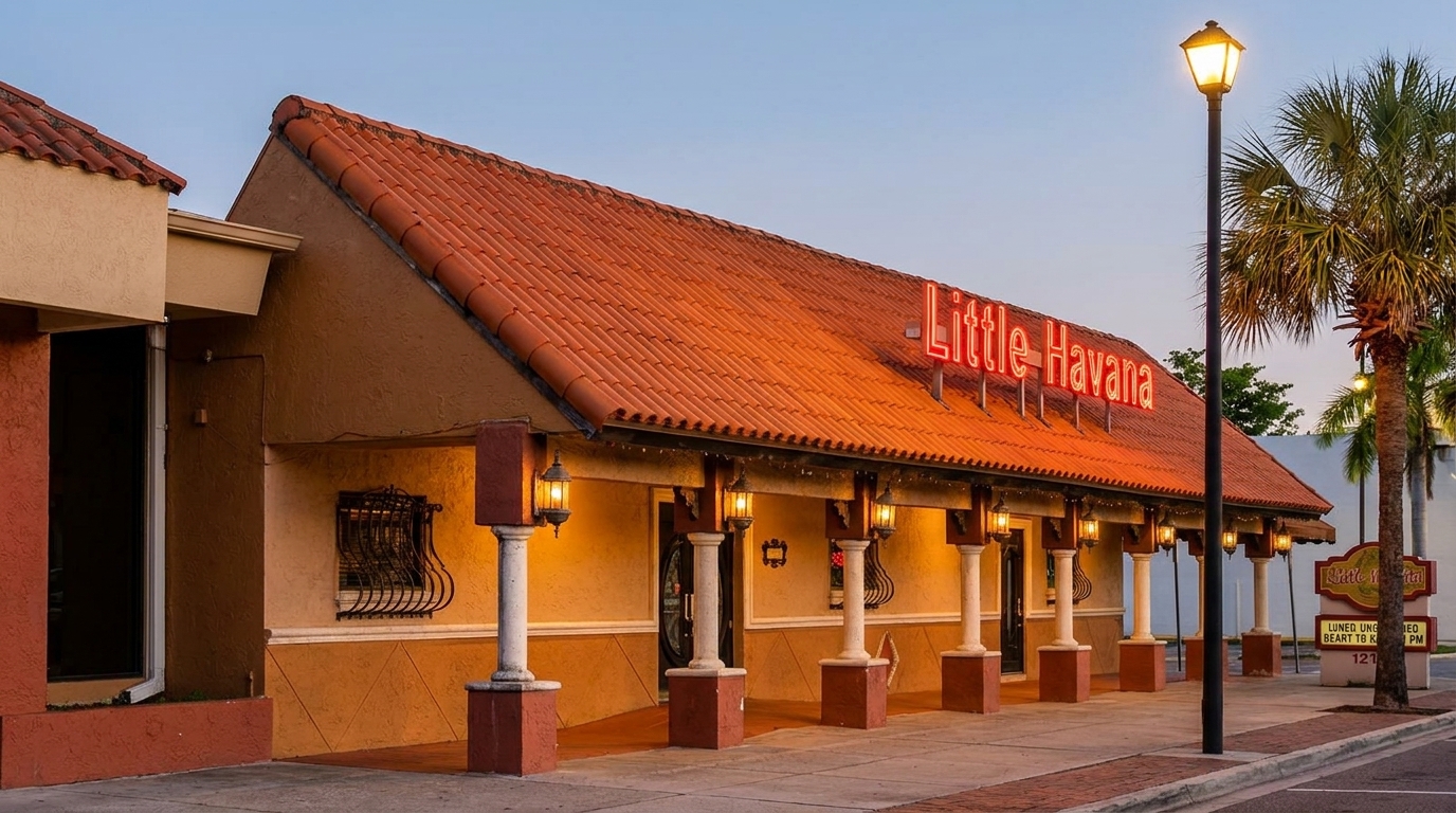 Exterior of Little Havana restaurant with a red tile roof, neon sign, and palm trees.