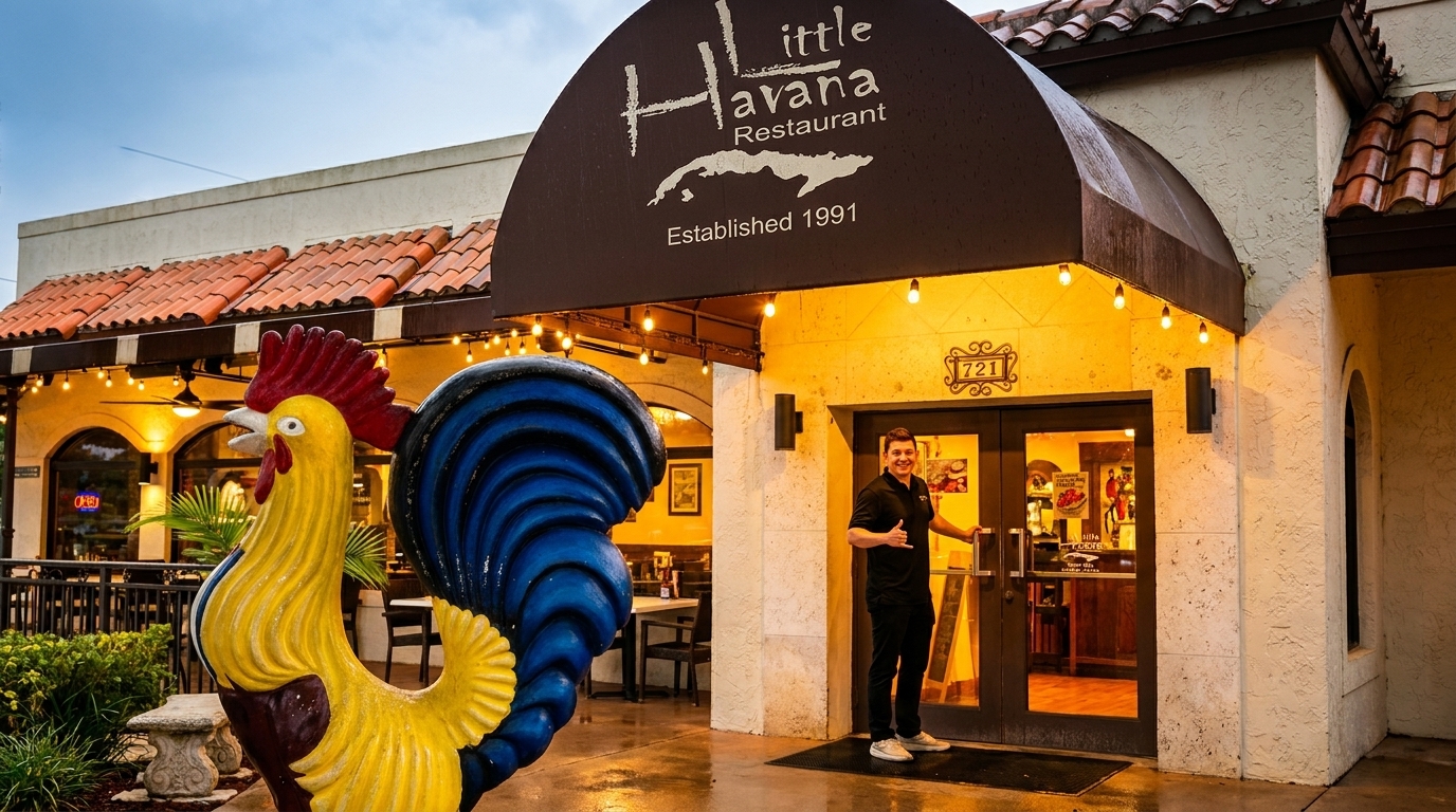 A man stands at the entrance of Little Havana Restaurant, next to a large colorful rooster statue.