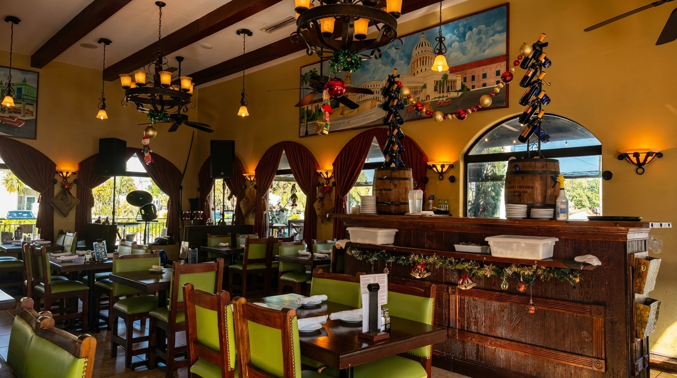 Warmly lit Cuban restaurant interior with green chairs, wooden tables, and festive decorations.