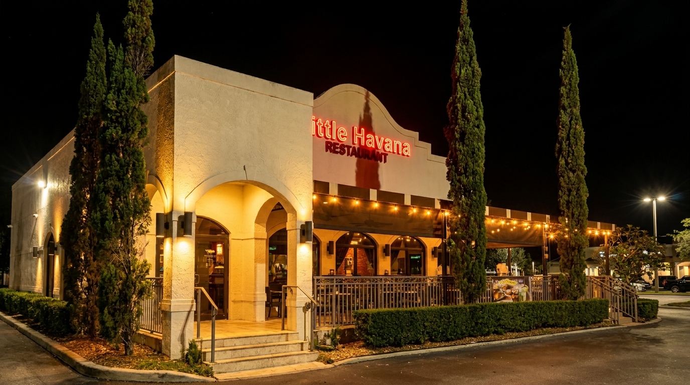 Exterior of Little Havana Restaurant at night, with glowing red neon sign and string lights over patio.
