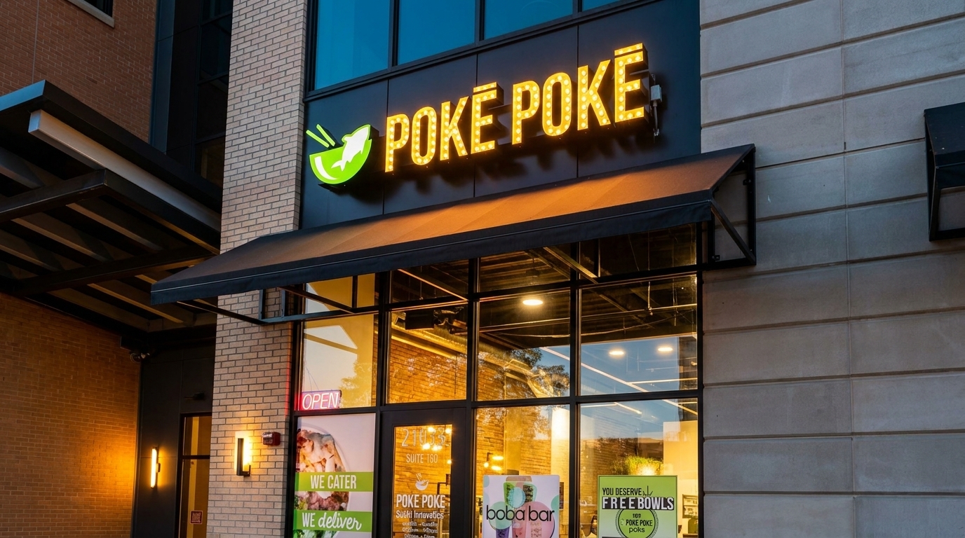 Exterior view of the Poke Poke restaurant with its illuminated sign and storefront windows.