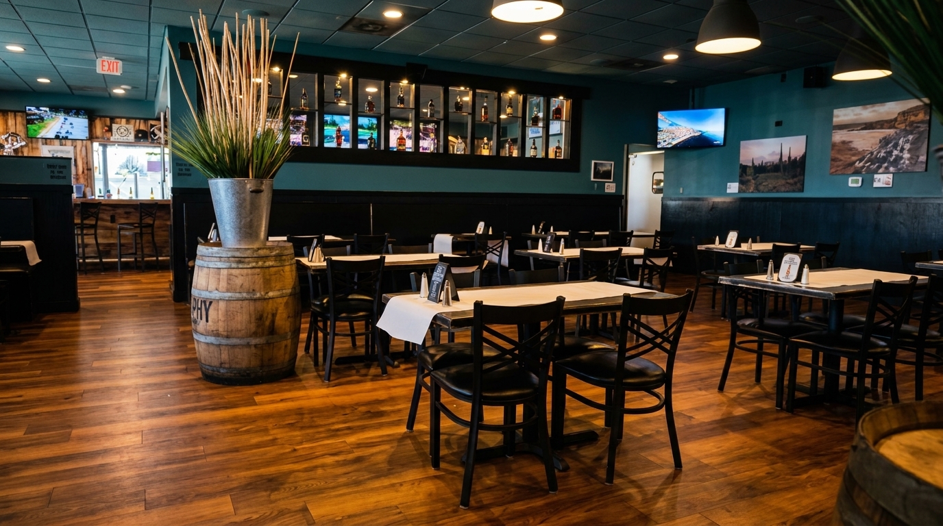Restaurant interior with wooden floors, teal walls, black tables, chairs, and a bar area.