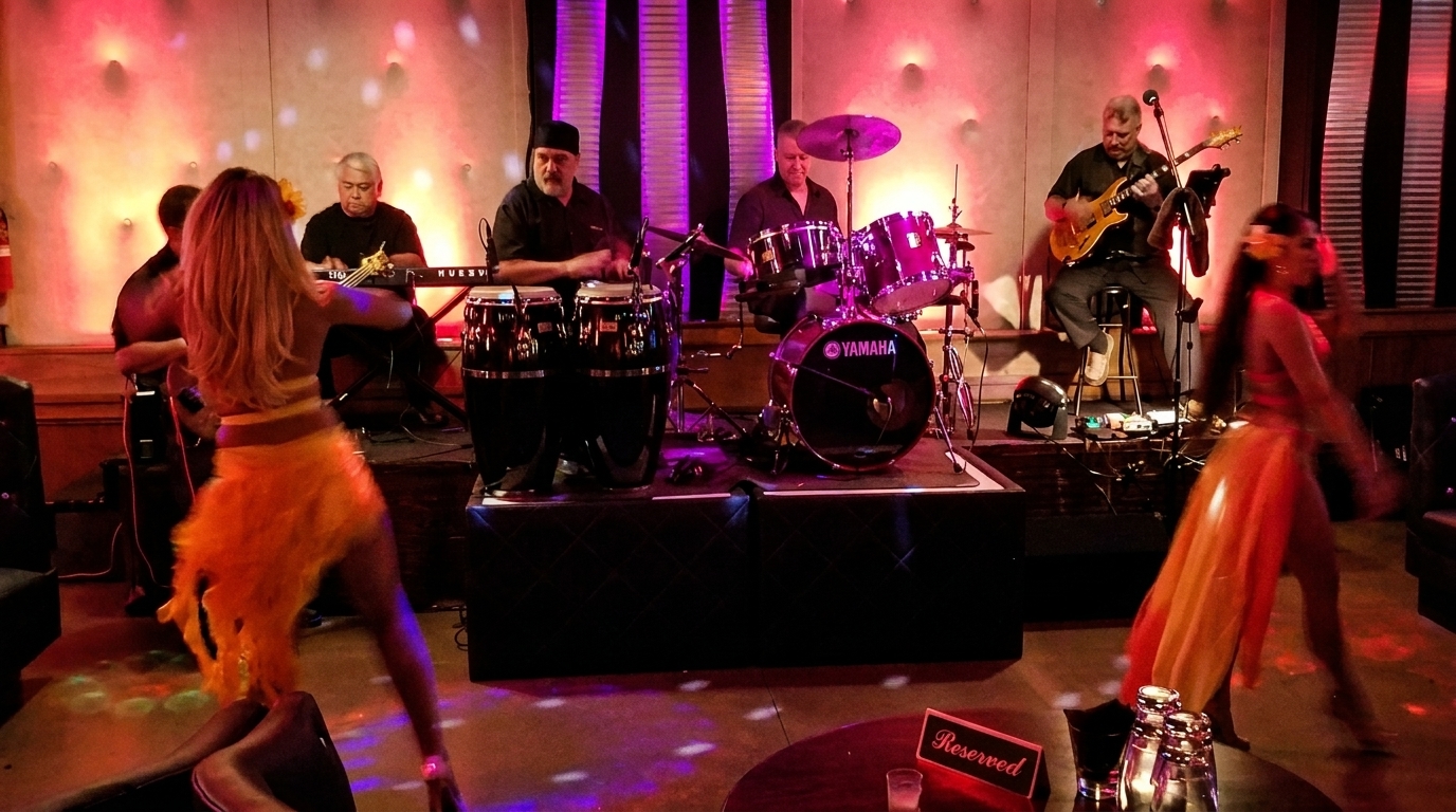 Live band with drums, congas, keyboard, and guitar, with two dancers in front of the stage.