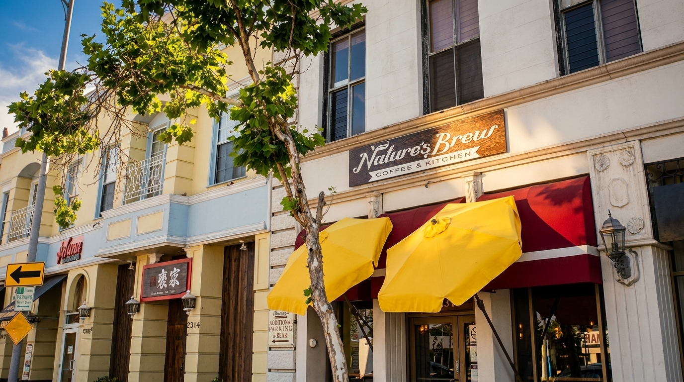 Nature's Brew Coffee & Kitchen storefront with red awnings and yellow umbrellas on a sunny day.