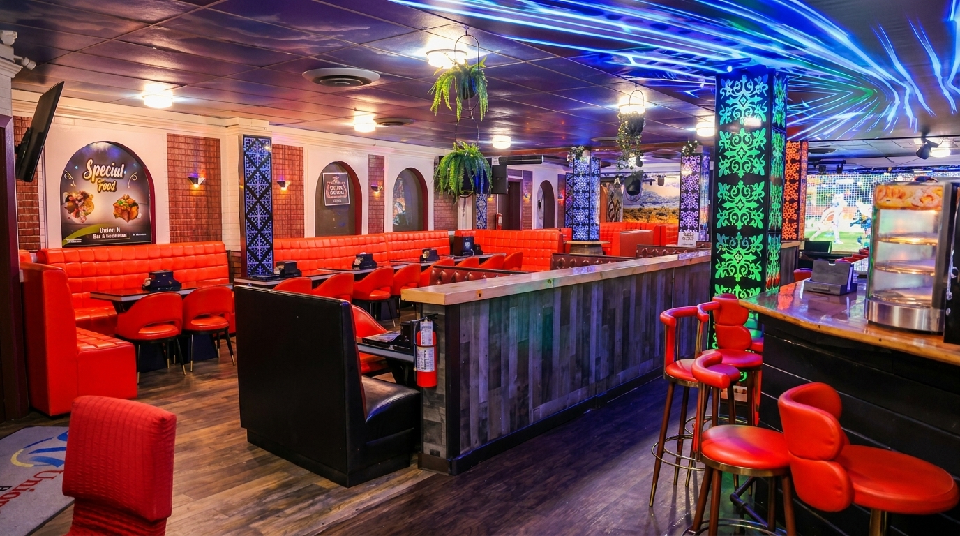 A vibrant restaurant interior with red booths, a wooden bar, and blue and green neon lighting.