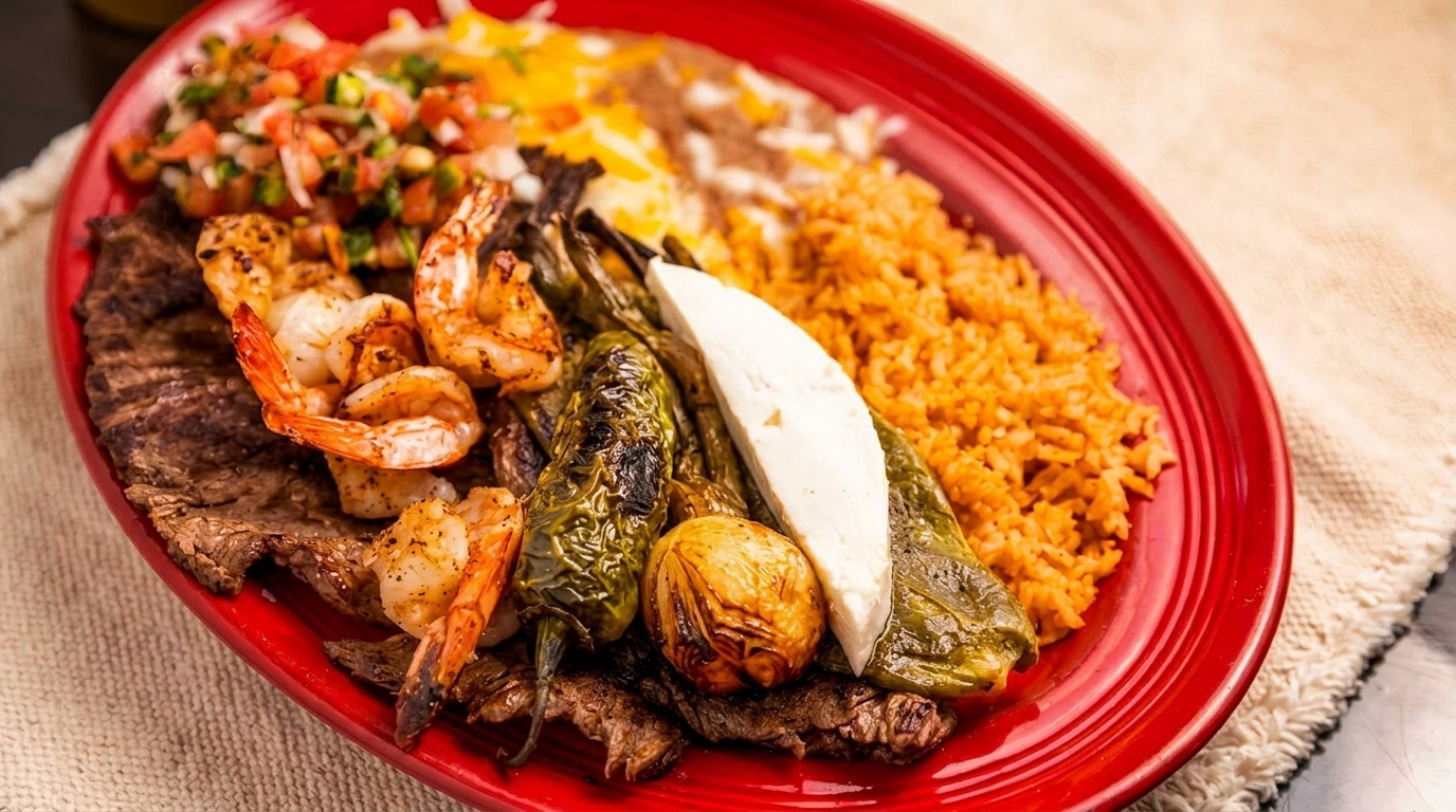 A vibrant red plate holds grilled steak, shrimp, peppers, onions, cheese, rice, beans, and pico de gallo.