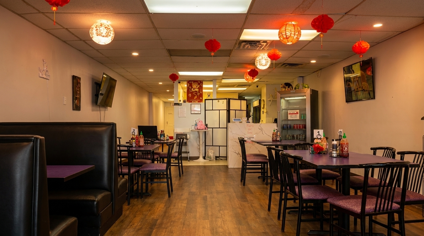 Interior of a restaurant with black booths, purple tables, and red and white lanterns hanging from the ceiling.