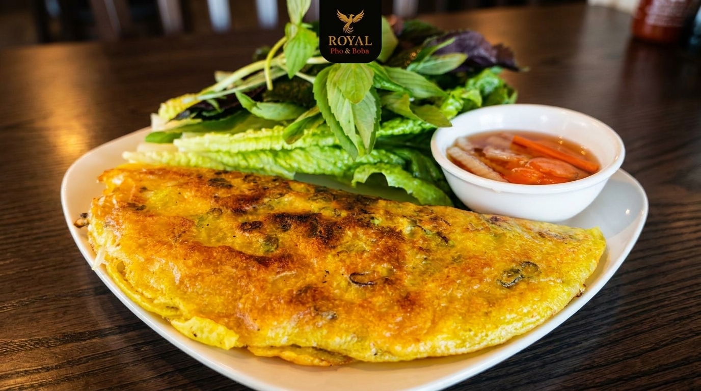 Crispy Vietnamese savory crepe (Banh Xeo) with fresh herbs and dipping sauce on a white plate.