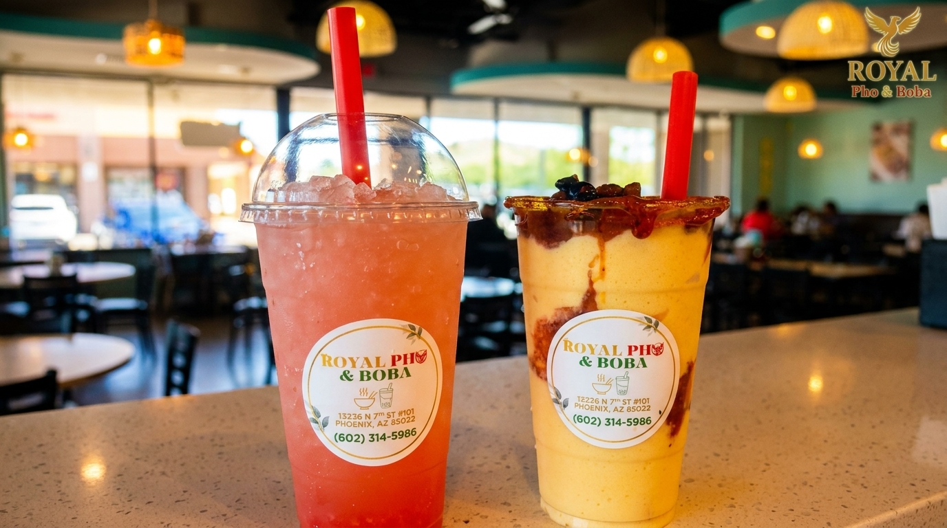 Two Royal Pho & Boba drinks, one pink and one yellow, on a counter inside the restaurant.