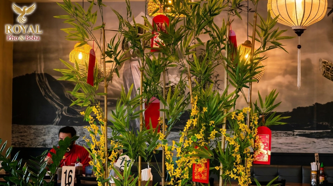 Bamboo and yellow flowers with red envelopes decorate a restaurant interior with a diner in the background.