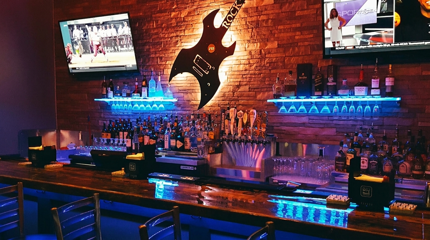A dimly lit bar with a large guitar sign, liquor bottles, beer taps, and TVs showing sports.