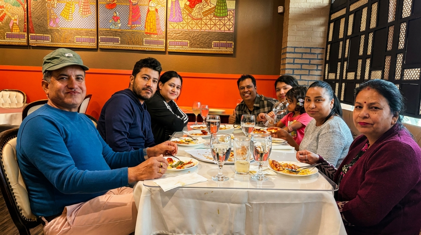 A family of seven enjoying a meal together at a restaurant with colorful wall art.