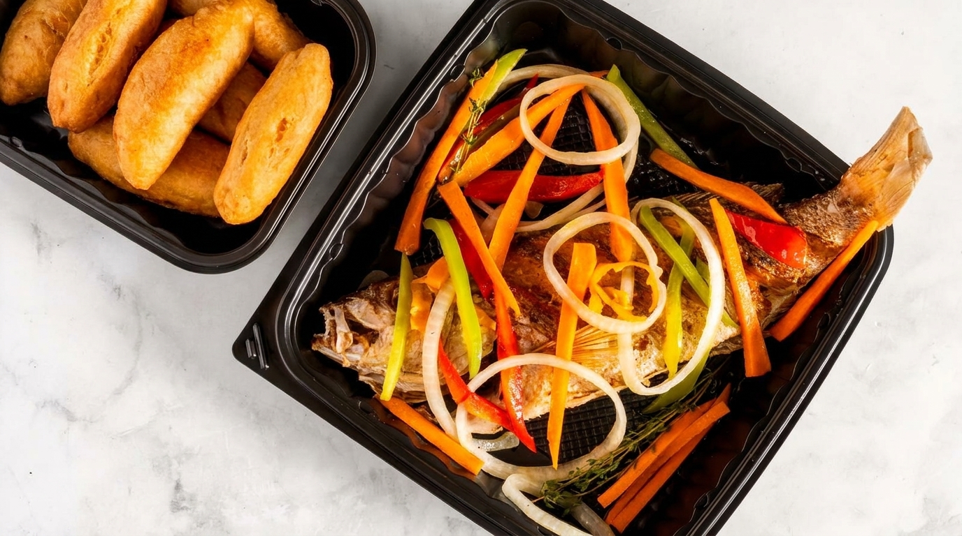 Fried fish with colorful vegetables and a side of fried dumplings in black takeout containers.