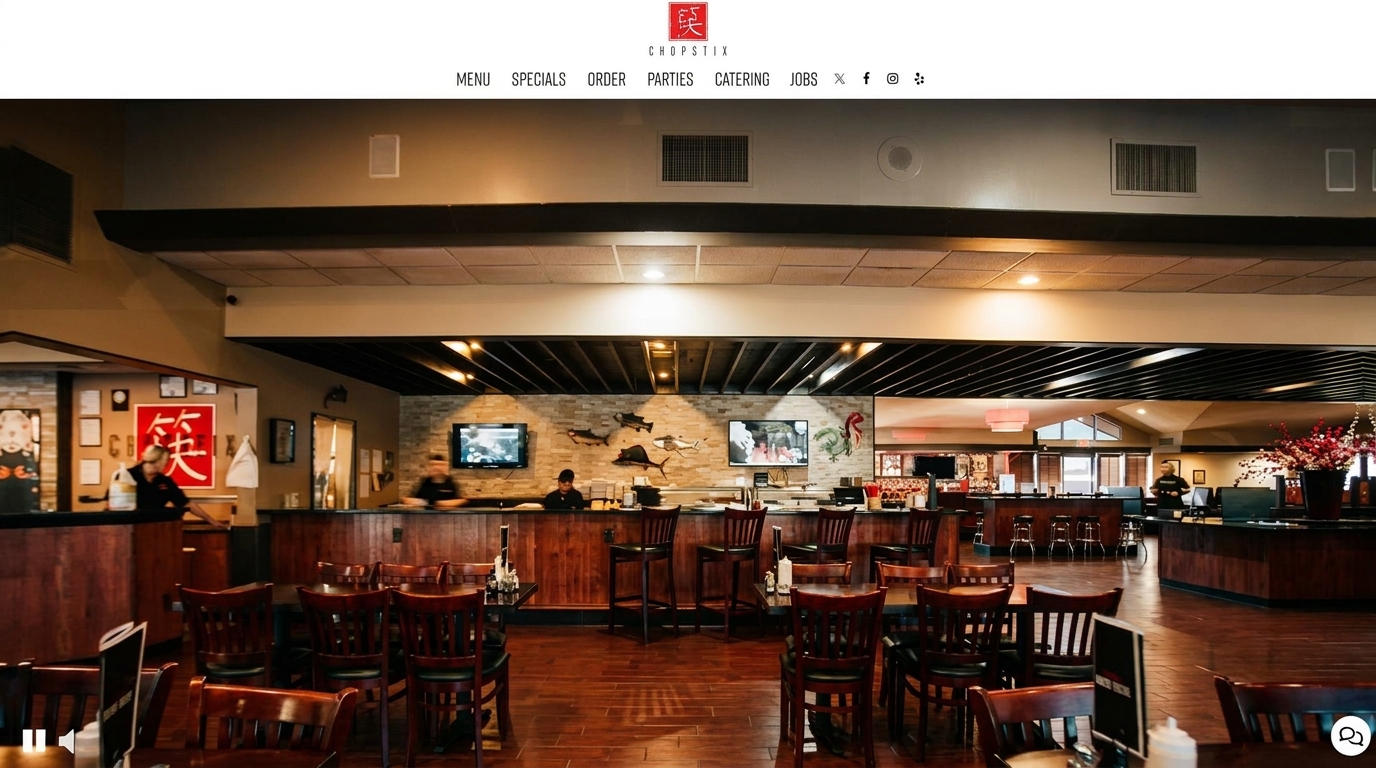 Interior of Chopstix restaurant with dining tables, bar seating, and staff behind the counter.