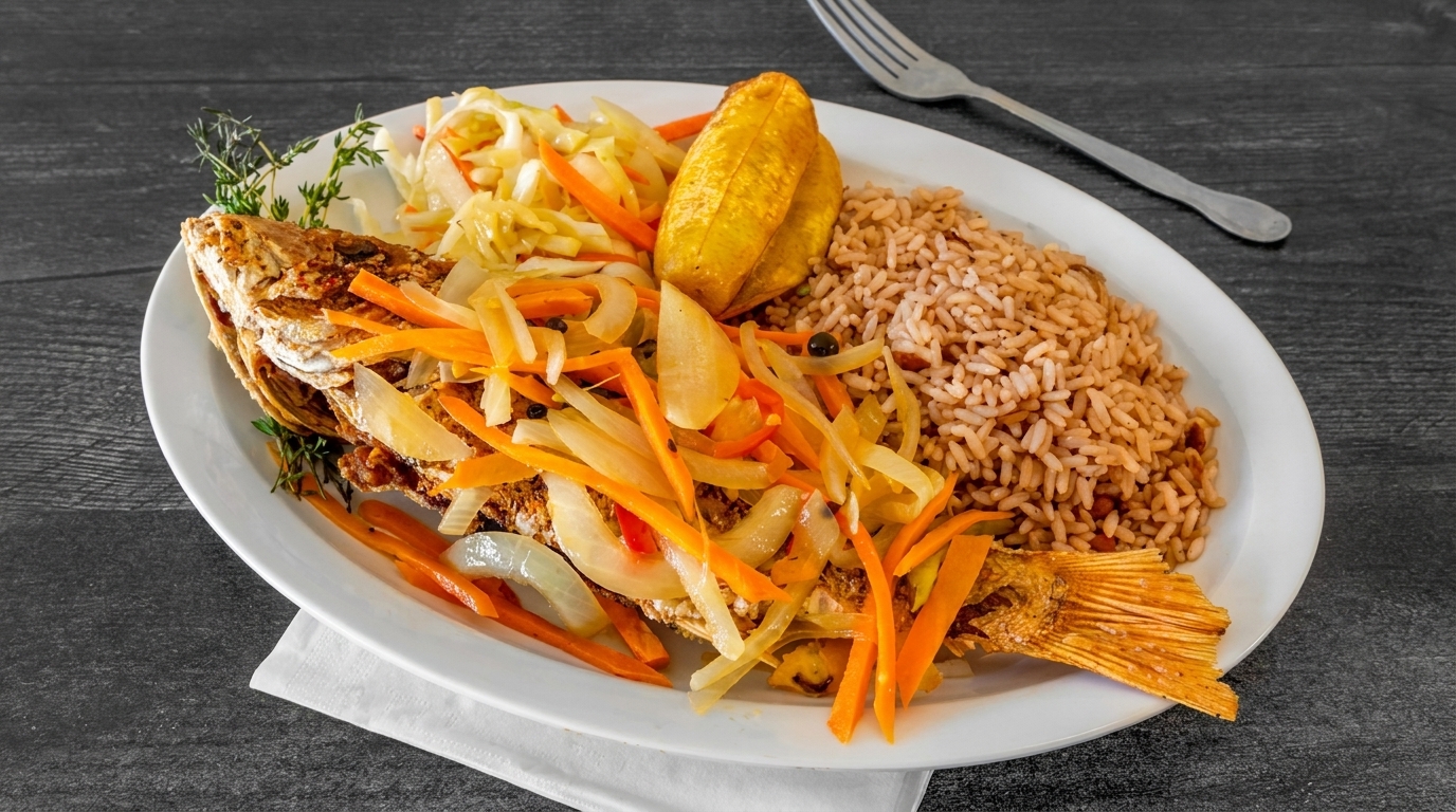 Whole fried fish topped with pickled vegetables, served with rice and peas, and fried plantains.