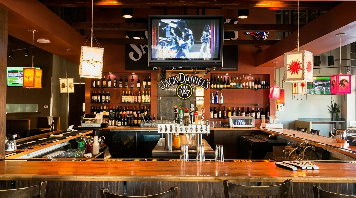 A well-stocked bar with a Jack Daniel's sign, beer taps, and a TV playing music videos.