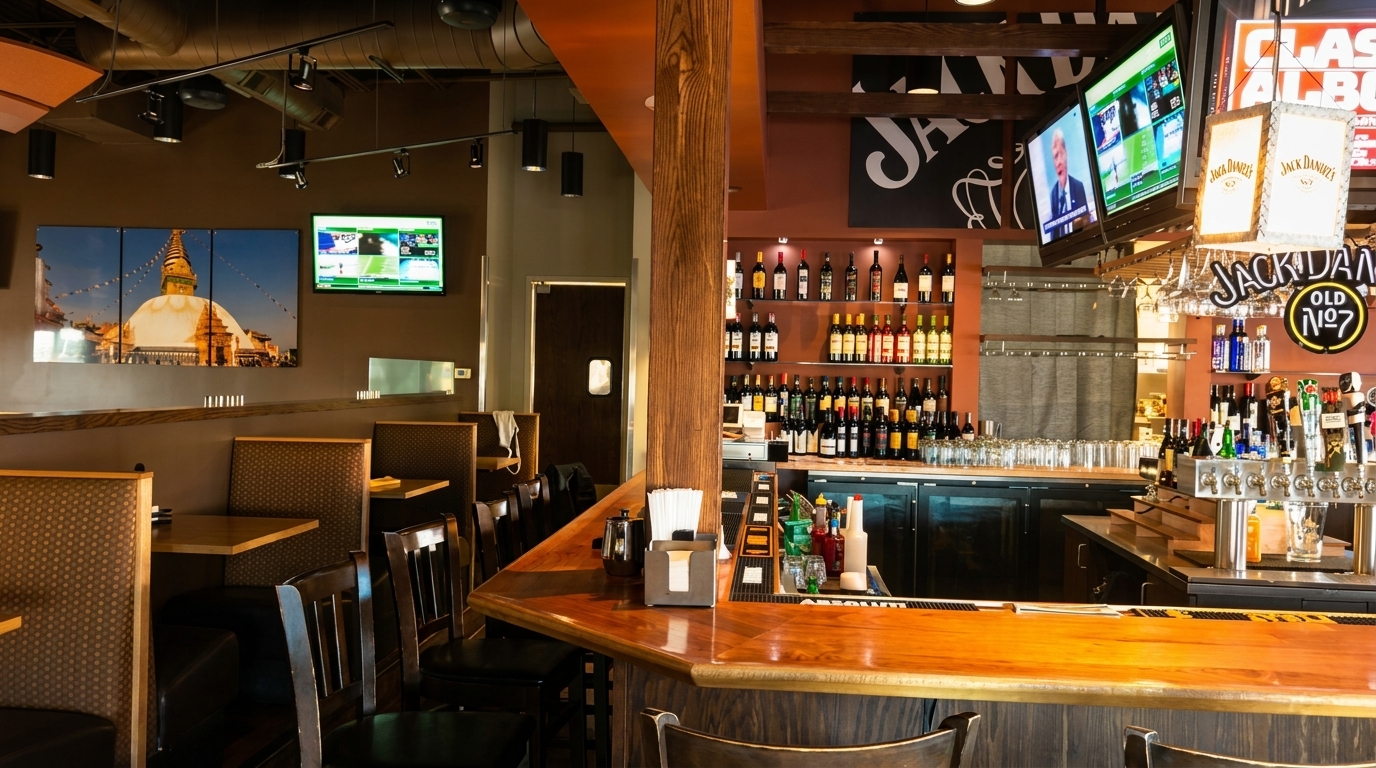 Interior view of a restaurant with a full bar on the right and booth seating on the left.