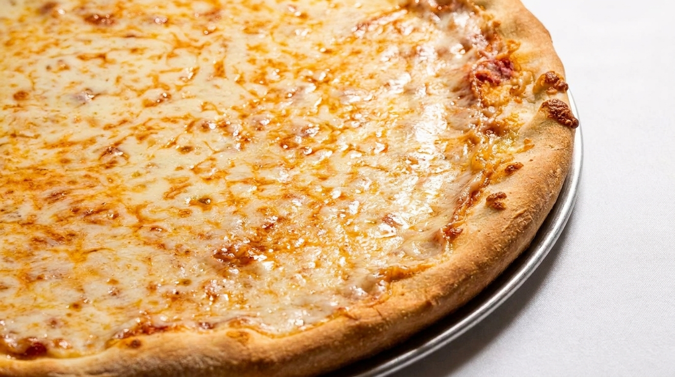 Close-up of a freshly baked cheese pizza with a golden crust on a metal pan.