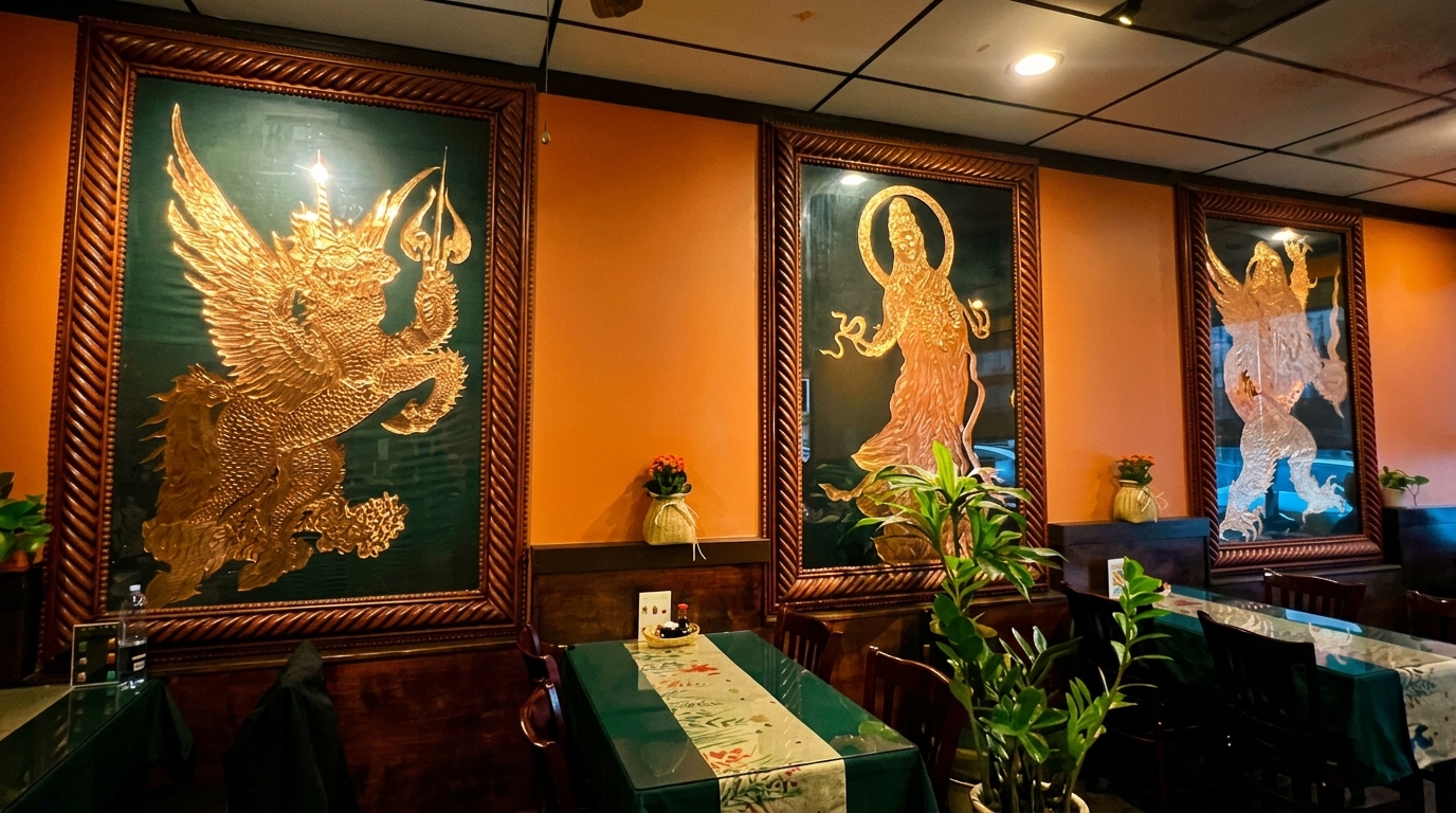 Restaurant interior with orange walls, dark wood trim, and three large framed artworks depicting mythical figures.