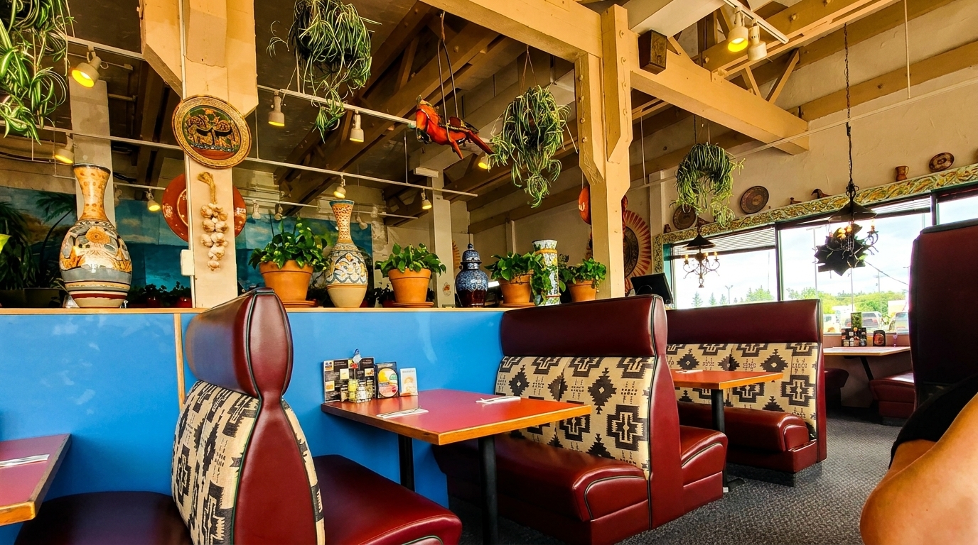 Restaurant interior with red booths, patterned upholstery, blue walls, and decorative vases and plants.