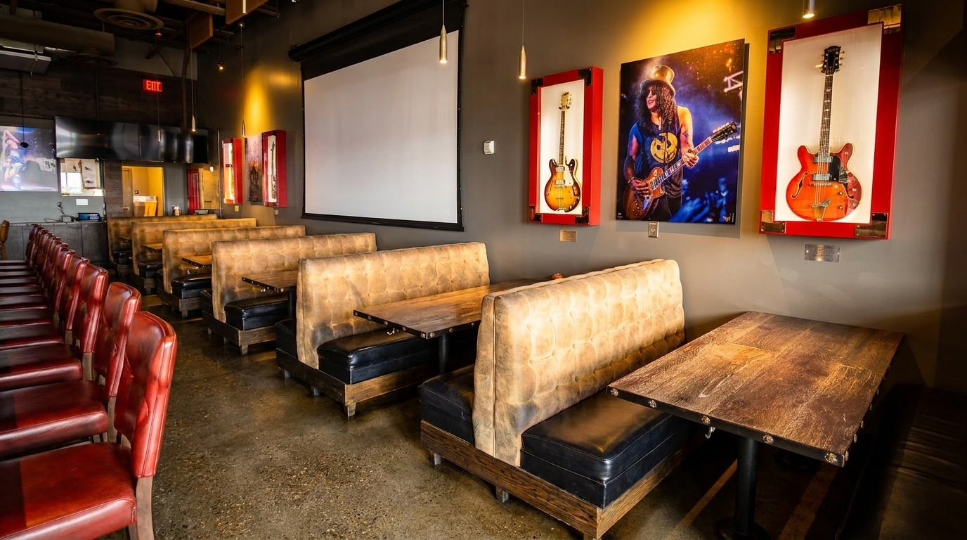 Restaurant interior with rows of red chairs, booth seating, and rock-and-roll themed decor.