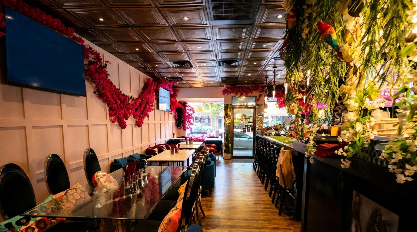 Vibrant restaurant interior with red floral decor, dark tables, and a bar adorned with greenery.