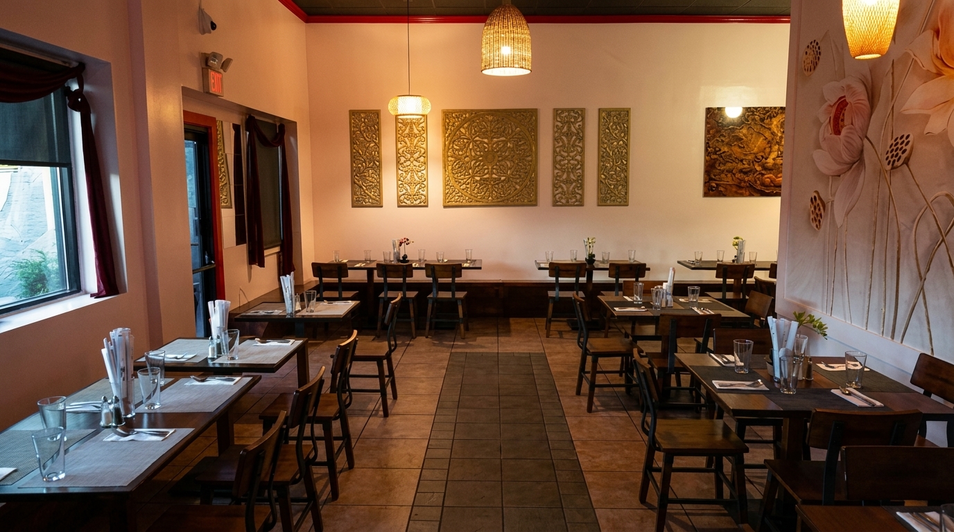 An empty restaurant dining room with dark wooden tables and chairs, and decorative wall art.
