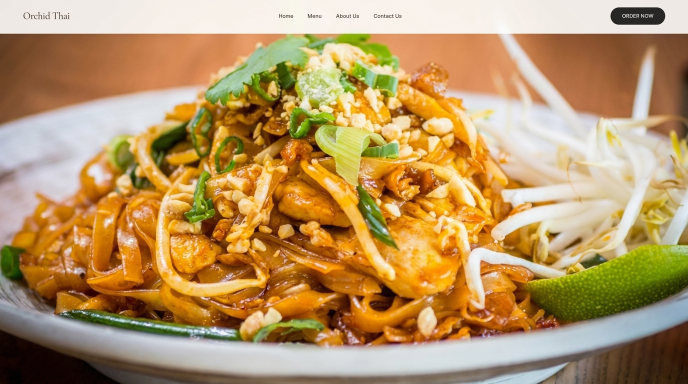 Close-up of a plate of Pad Thai noodles with chicken, peanuts, bean sprouts, and lime.