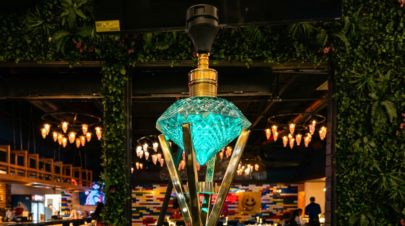 A glowing blue diamond-shaped hookah on a gold stand in a restaurant with green walls.