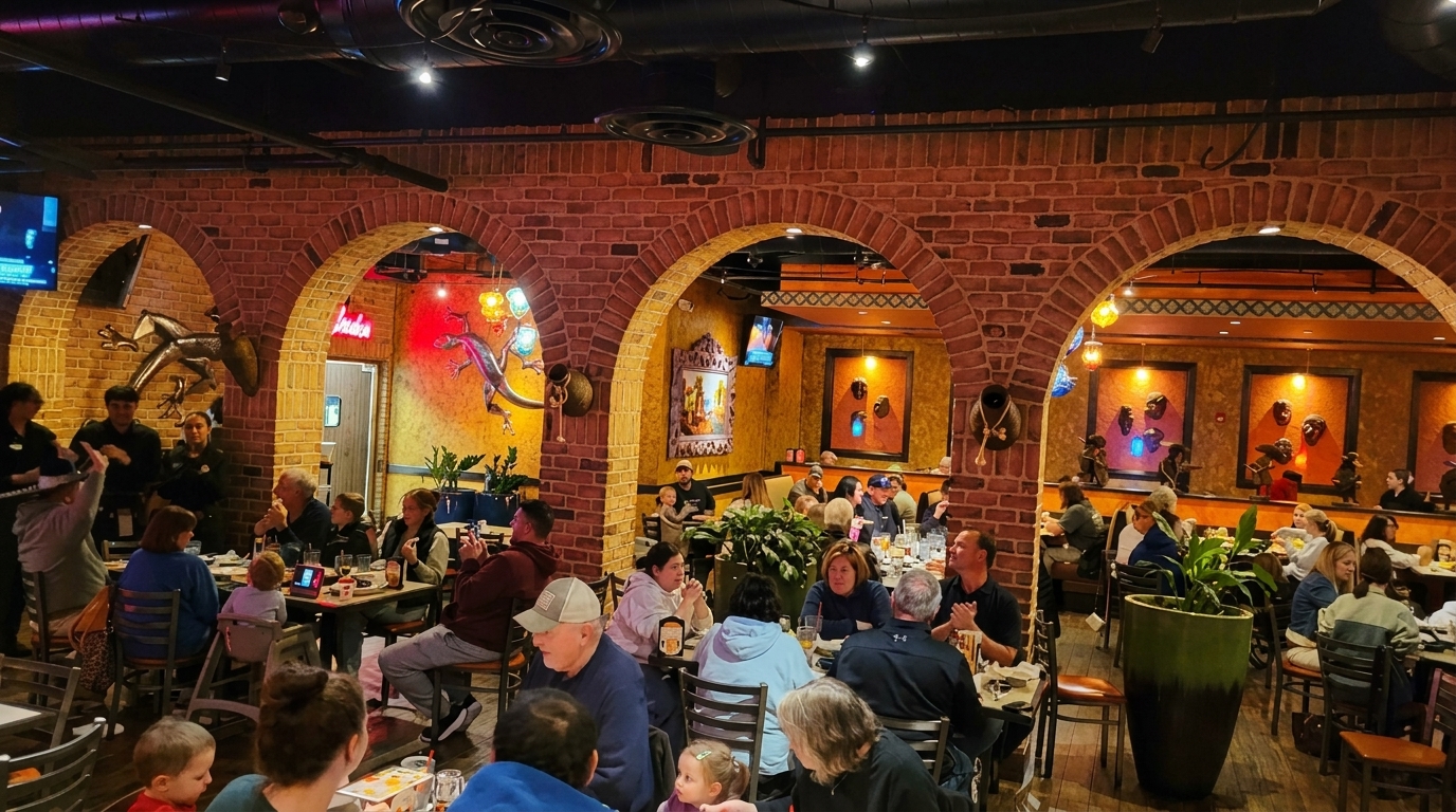 A bustling restaurant interior with brick arches, patrons dining at tables, and decorative wall art.
