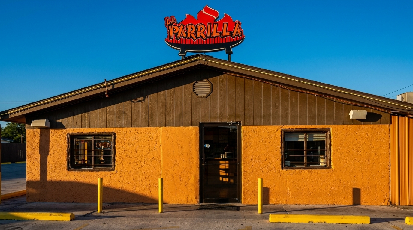 The exterior of La Parrilla restaurant, an orange building with a red and black sign under a clear blue sky.