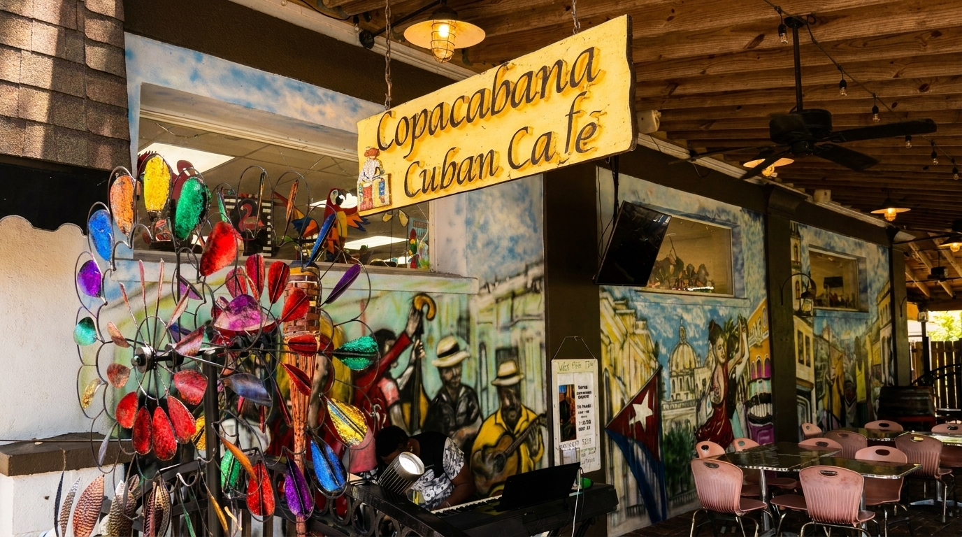 Copacabana Cuban Cafe sign hangs above a vibrant mural, colorful wind spinners, and outdoor seating.